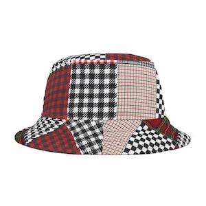 Op de afbeelding: Een patchwork emmerhoed met verschillende patronen, waaronder rood-zwarte ruit, zwart-witte pied-de-poule en een rood-beige ruit. De hoed heeft een ronde kroon en een brede rand, ideaal voor bescherming tegen de zon.