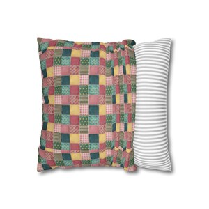 May include: A patchwork pillow with a red, yellow, green, and blue pattern. The pillow is paired with a white pillow with gray stripes.