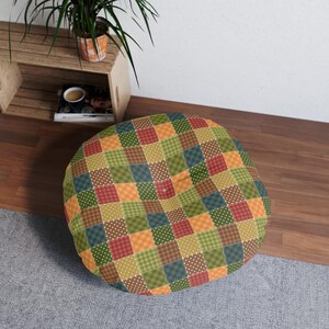 May include: A round floor pillow with a patchwork design featuring squares of red, orange, green, brown, and white with polka dots.