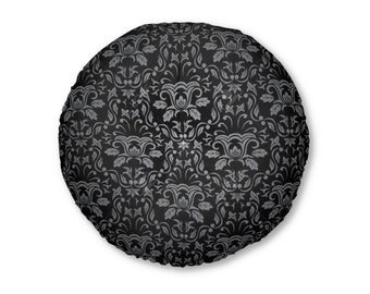 Puede incluir: Un cojín redondo de color negro y plateado con un diseño de damasco.