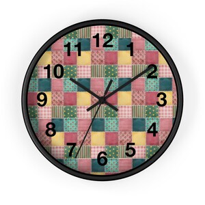 May include: A round wall clock with a black frame and a patchwork design. The clock face features a quilt-like pattern with various colors, including red, yellow, green, and blue. The numbers 1 through 12 are printed in black around the clock face.
