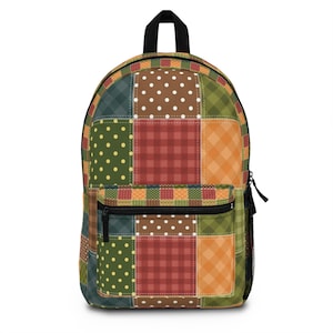 Könnte beinhalten: Ein Rucksack im Patchwork-Stil mit verschiedenen Farben und Mustern, darunter Grün, Rot, Orange und Gelb. Der Rucksack hat ein großes Hauptfach und eine kleinere Tasche vorne.