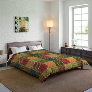 Könnte beinhalten: Ein Patchwork-Steppbett mit verschiedenen Farben und Mustern, darunter Grün, Braun, Orange, Rot und Gelb. Das Bettzeug liegt auf einem Bett mit weißen Kissen und einem braunen Holzkopfteil.