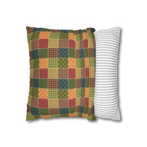 May include: A set of two decorative cushions. One cushion has a patchwork design with squares of green, orange, red, and blue. The other cushion is white with grey stripes.