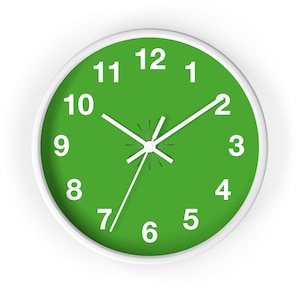May include: A white framed clock with a green face and white numbers and hands. The clock face has the numbers 1 through 12.