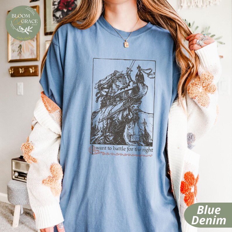 May include: A blue denim t-shirt with a vintage illustration of a knight on horseback. The text "I want to battle for the right" is printed below the illustration.