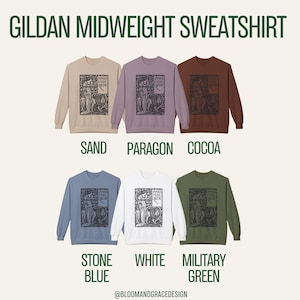 Puede incluir: Seis sudaderas Gildan Midweight en colores arena, paragon, cacao, azul piedra, blanco y verde militar. Cada una presenta un estampado gr&aacute;fico negro de una figura y un le&oacute;n con el texto Spenser's Faerie Queene. El texto Bloomandgracedesign est&aacute; abajo.