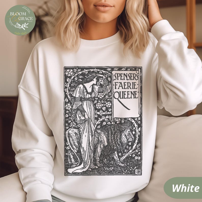 Puede incluir: Sudadera blanca con una ilustraci&oacute;n en blanco y negro de "Spenser's Faerie Queene". El dise&ntilde;o incluye una mujer, un le&oacute;n y elementos florales. La sudadera tiene cuello redondo y mangas largas. El logotipo de Bloom & Grace es visible en la esquina superior izquierda.