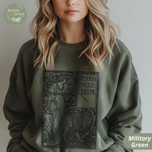 Puede incluir: Sudadera verde militar con un dise&ntilde;o gr&aacute;fico negro de Spenser's Faerie Queene. El dise&ntilde;o incluye una ilustraci&oacute;n de una mujer y un le&oacute;n. La sudadera es de color liso y tiene cuello redondo.