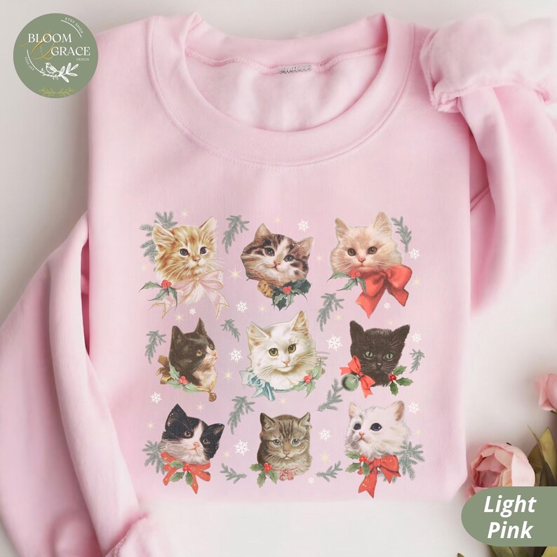 Peut inclure: Sweat-shirt rose clair orn&eacute; d'une grille de neuf portraits de chats, chacun orn&eacute; d'un n&oelig;ud festif et de verdure. Le logo Bloom & Grace est visible en haut &agrave; gauche. Le texte "Light Pink" est en bas &agrave; droite.