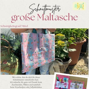 Könnte beinhalten: Eine große Tragetasche mit einem rosa, blauen und weißen Muster. Die Tasche hat einen Klappenverschluss und wird vor Pflanzen und einem grünen Metallobjekt gehalten. Der Text auf dem Bild lautet "Schnittmuster große Maltasche".