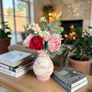 May include: A set of three ceramic mugs with a speckled, matte finish. The mugs are in shades of cream, light gray, and dark gray. Each mug has a simple, minimalist design and a rounded handle.