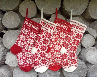 May include: Four red and white knitted Christmas stockings with snowflake patterns and personalized names:  'Alienor', 'Megan', 'Nora', and 'Anais'.