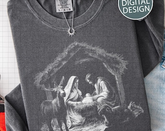 Könnte beinhalten: Dunkelgraues Langarmshirt mit einer Grafik der Weihnachtsgeschichte. Das Bild zeigt Maria, Josef und das Jesuskind in einer Krippe, mit einem Tier. Eine silberne Halskette mit Sonnenanhänger befindet sich auf dem Shirt. Der Text "PNG DIGITAL DESIGN" steht auf dem Shirt.