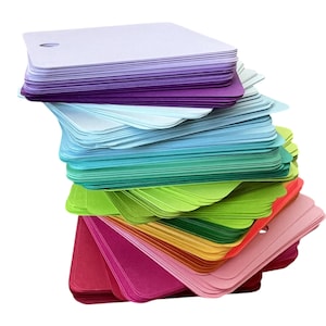 May include: A stack of colourful cardstock paper in various shades of purple, blue, green, yellow, orange, red, and pink. The paper is arranged in a rainbow pattern and is ready for crafting projects.