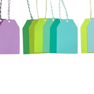 May include: A set of 18 colourful gift tags with string attached. The tags are in various shades of pink, orange, purple, green, blue, and yellow.