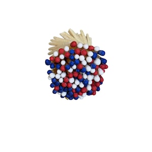 May include: A bundle of matches with red, white, and blue tips, arranged in a circular shape. The match heads are clustered together, creating a vibrant display of color. The wooden stems are visible at the base of the bundle.