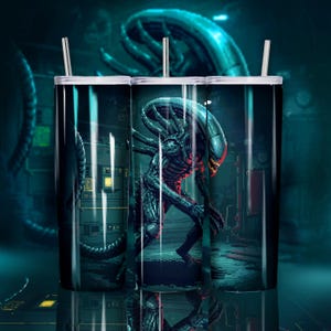 Op de afbeelding: Een cilindrische tumbler met een gepixeld beeld van een Alien-wezen in een donkere, industriële omgeving. Het ontwerp omvat een zwarte en grijze Alien met een rode mond, tegen een achtergrond van machines en blauwe verlichting. De tumbler heeft een wit rietje.
