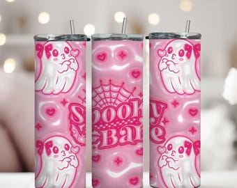 May include: Pink tumbler featuring a cute ghost design with bows, hearts, and the words "Spooky Babe." The tumbler has a silver lid and a straw. The design is in white and pink.