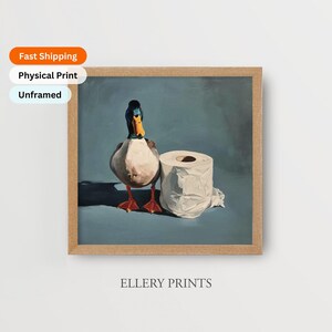 May include: A framed print featuring a duck and a roll of toilet paper. The duck has a blue and black head, a yellow beak, and red feet. The print is labeled "Ellery Prints".