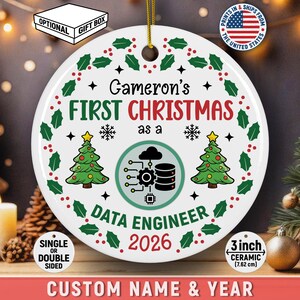 May include: A round white 3-inch ceramic ornament featuring a green holly wreath border, two green Christmas trees, and a central icon of a cloud, server, and circuit. Text reads: Gameron's FIRST CHRISTMAS as a DATA ENGINEER 2026.
