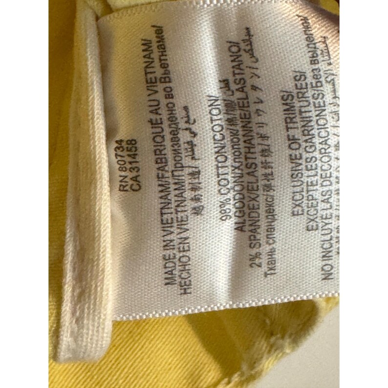 May include: A close-up of a clothing label with text. The label states "MADE IN VIETNAM" and details the fabric content as 98% cotton and 2% spandex. The label also includes the RN and CA numbers.