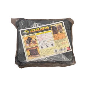 May include: A black plastic storage case, wrapped in clear plastic, with a printed label. The label features Japanese text and illustrations, including the words "HYPER YO-YO" and "SPINNERS BOX HEAVY". The case appears to be designed for storing yo-yos.