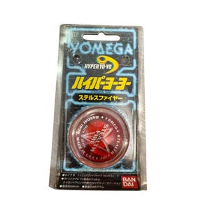 May include: A Yomega Hyper Yo-Yo in its original packaging. The yo-yo is red with the text "STEALTH FIRE" and "YOMEGA" on it. The packaging has Japanese text and the words "HYPER YO-YO". The yo-yo measures approximately 5.9 cm in diameter and weighs about 45 grams.