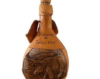 Fiaschetta vintage in pelle realizzata a mano con decorazione a rilievo raffigurante un bue, proveniente da Talca, Cile.