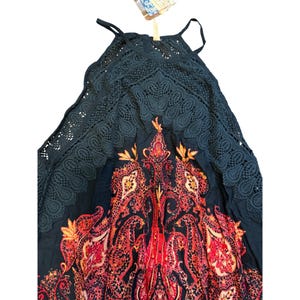 May include: A dark navy blue halter top dress with a paisley pattern in red, orange, and yellow. The top features a lace overlay and spaghetti straps. The dress is a bohemian style.