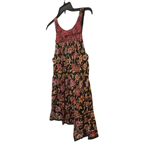 May include: A sleeveless floral print dress with a scoop neckline. The dress has a black background with a colourful floral pattern in shades of red, pink, orange, and yellow. The top portion of the dress is a textured red fabric.