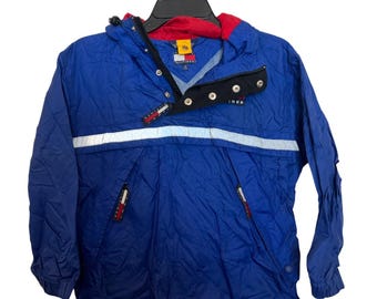 May include: Blue and red hooded jacket with a white reflective stripe across the chest. The jacket has a black collar with snap closures and a small logo on the chest. The jacket has two zippered pockets and a drawstring at the bottom.