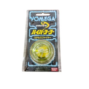 May include: A new, packaged Yomega Hyper Yo-Yo. The package is black and blue with Japanese text and the words "Yomega" and "Hyper Yo-Yo". The yo-yo is yellow and green with the words "Stealth Fire".