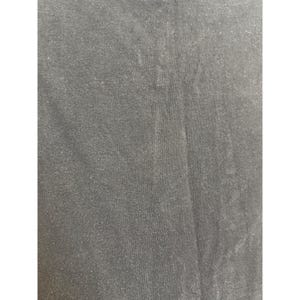 Puede incluir: Primer plano de una tela gris oscuro con una superficie texturizada. La tela parece ser un material de punto o tejido, con sutiles variaciones de tono y textura en la superficie.