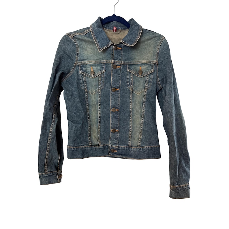 May include: A blue denim jacket with a button closure and two front pockets. The jacket has a faded look and is made of a soft, comfortable material.