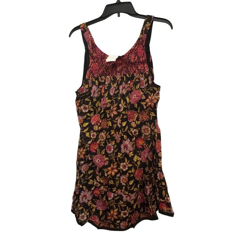 May include: A sleeveless floral print dress with a black background, featuring pink, yellow, and orange flowers. The top section has a textured, reddish-pink fabric. The dress hangs on a black hanger.
