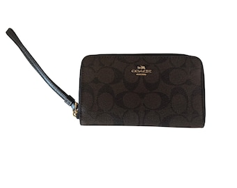 Portafoglio da polso Coach Signature in pelle marrone con dettagli dorati.