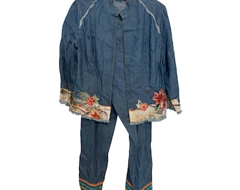 May include: A blue denim two-piece set consisting of a long-sleeve jacket and matching pants. The jacket features a frayed hem, a collar, and floral embroidery at the bottom. The pants have a colorful patterned border at the cuffs.