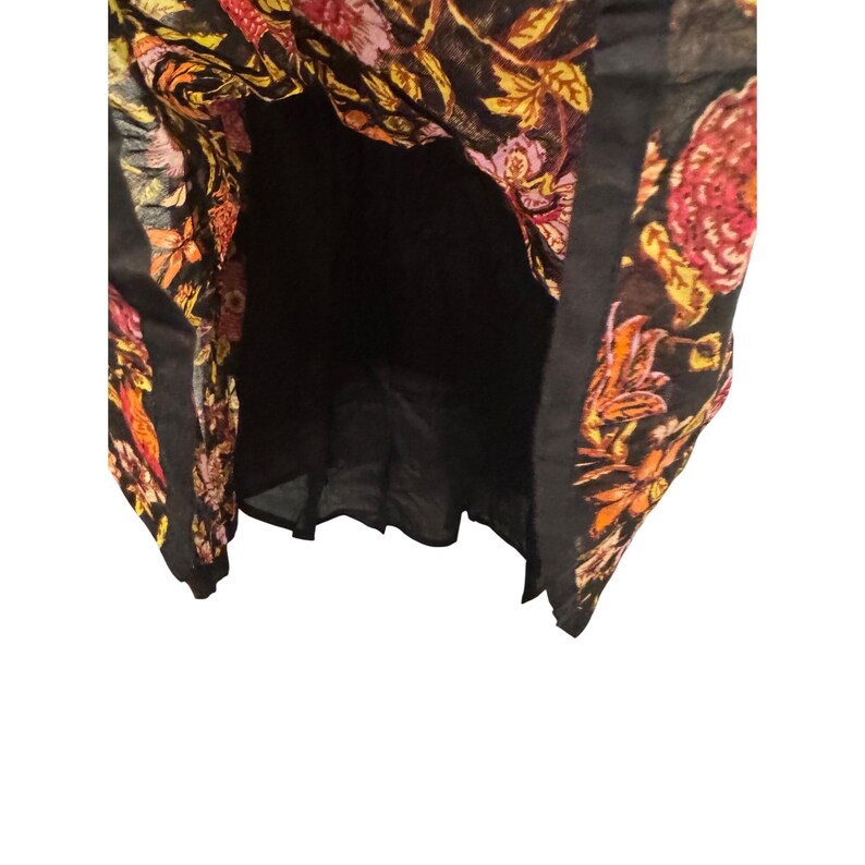 May include: A black dress featuring a vibrant floral design in red, orange, and yellow hues. The dress has a black lining and a flowing shape. The floral pattern is intricate and covers the entire garment.