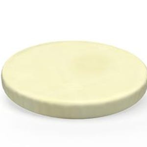 May include: A round, pale yellow soap bar with a slightly textured surface. The soap has a simple, minimalist design and appears to be unscented. The bar is approximately 4 inches in diameter.