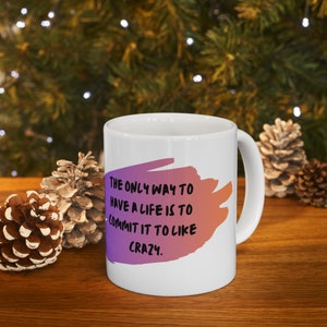 May include: White ceramic mug with a pink and orange gradient design and black text that reads "THE ONLY WAY TO HAVE A LIFE IS TO COMMIT IT TO LIKE CRAZY."