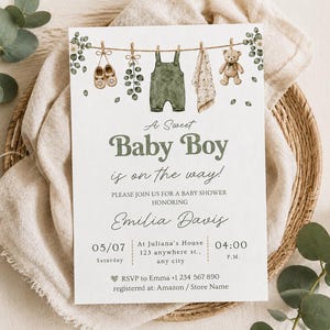 May include: A white rectangular baby shower invitation card featuring a clothesline illustration with baby shoes, green overalls, a cloth, and a teddy bear. Text reads: A Sweet Baby Boy is on the way! Please join us for a baby shower honouring Emilia Davis.