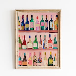 May include: A framed painting of wine bottles in various colors, including blue, green, and red, arranged on shelves. The artwork has a light pink background and a gold-colored frame, creating a decorative piece for a home or bar.