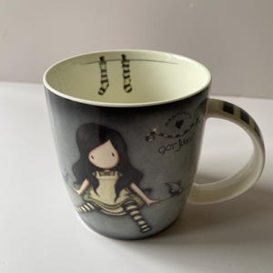 Taza de porcelana "En la cima del mundo" de Gorjuss de Santoro, c. 2010. Muñeca inocente y caprichosa de Suzanne Woollcott, chica gótica.