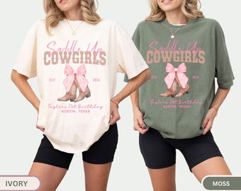 May include: Ivory and moss-colored t-shirts with the text "Saddle Up Cowgirls" in pink and brown. The design includes a pink bow, cowboy boots, and the text "Taylor's 21st Birthday, Austin, Texas, 2024".
