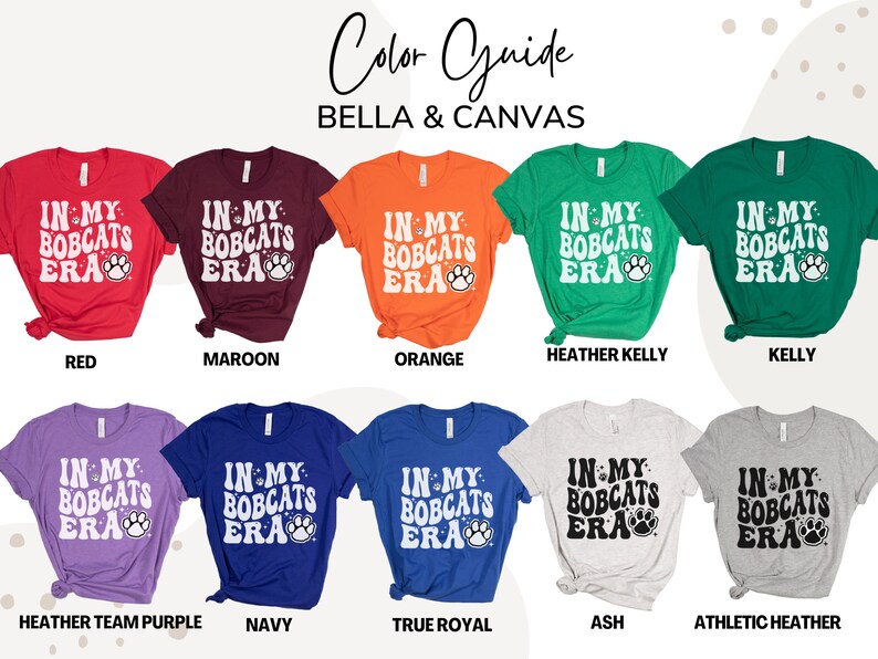 K&ouml;nnte beinhalten: Farbguide f&uuml;r Bella + Canvas T-Shirts in verschiedenen Farben, darunter Rot, Maroon, Orange, Heather Kelly, Kelly, Heather Team Purple, Navy, True Royal, Ash und Athletic Heather. Jedes Shirt zeigt den Text "IN MY BOBCATS ERA" mit einem Pfotenabdruck.