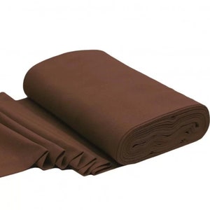 Könnte beinhalten: Eine Rolle braunen Stoffes, teilweise abgerollt, um die Textur und die Falten zu zeigen. Der Stoff hat eine einfarbige, warme braune Farbe und scheint ein mittelschweres Material zu sein, das für verschiedene Nähprojekte geeignet ist.