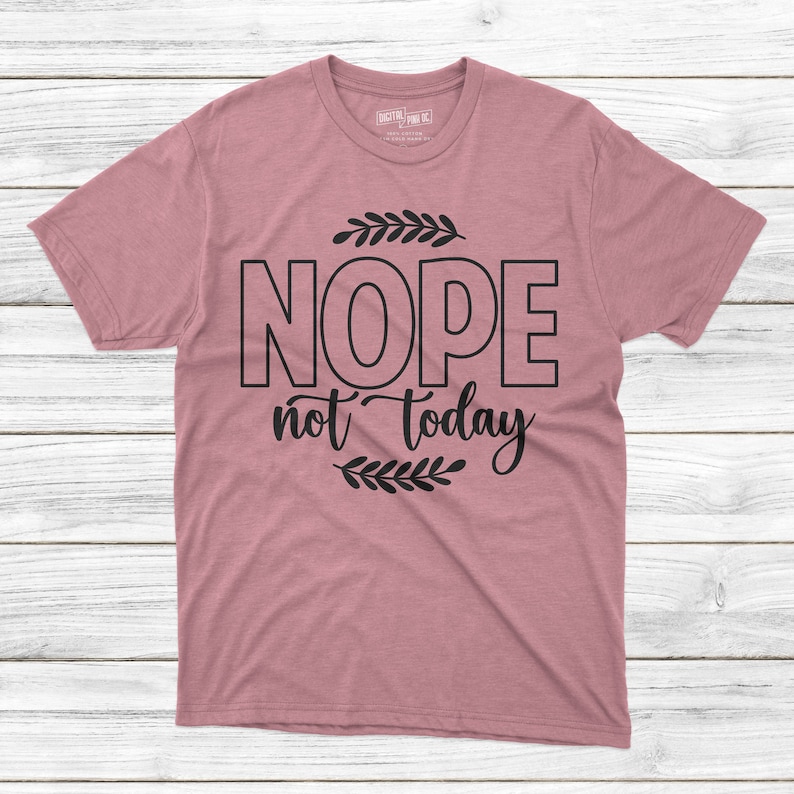 May include: A pink t-shirt with black text that reads "NOPE not today" with a small leafy design above and below the text.