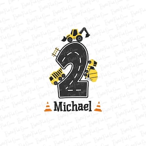 Könnte beinhalten: Eine schwarze Zahl Zwei mit einem Straßen-Design, umgeben von gelben Baufahrzeugen. Der Text "Michael" befindet sich unter der Zahl.