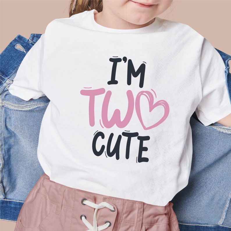 Puede incluir: Camiseta blanca con texto negro que dice "I'm Two Cute" con un coraz&oacute;n rosa.